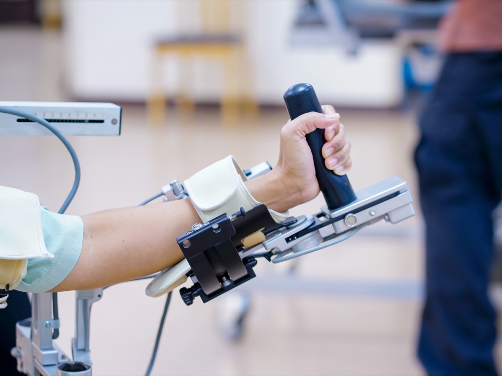woman wear machine arm for physical therapy. By defining how a robot driven moving technique can be improved to achieve better results in physical rehabilitation.